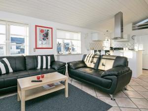 ein Wohnzimmer mit 2 Ledersofas und einem Tisch in der Unterkunft 6 person holiday home in L kken in Løkken