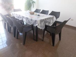 a dining room table with a white tablecloth and chairs at Apartamento Familiar Cusco in Cusco
