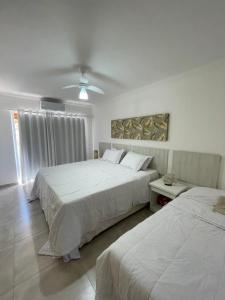 - une chambre avec 2 lits et un ventilateur de plafond dans l'établissement Casa em condomínio fechado-Arraial D'ajuda-Alto da Pitinga, à Arraial d'Ajuda