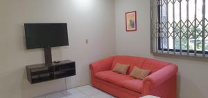 a living room with a red couch and a flat screen tv at Departamentos Manta in Manta