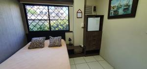 1 dormitorio con 1 cama con 2 almohadas y ventana en Apartamento habitación pequeña para ejecutivos o parejas, en Manta