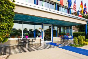 a patio with chairs and tables outside of a building at Hotel Maria in Luisago