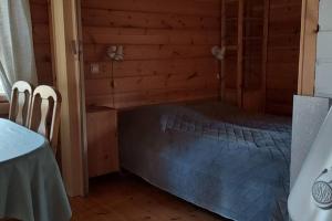 a bedroom with a bed in a wooden room at Mökki Jerisjärven rannalla in Muonio