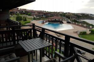a balcony with a bench and a swimming pool at Villa Aurora, komplex Sozopolis in Sozopol