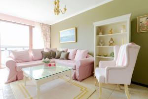 a living room with a pink couch and a table at Villa Aurora, komplex Sozopolis in Sozopol