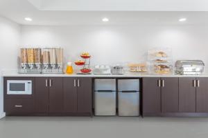 a kitchen with brown cabinets and a counter top at Econolodge Inn and Suites in Medicine Hat