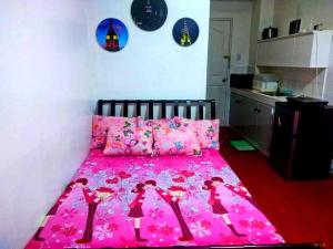 a bedroom with a pink bed with dolls on it at 8 JOAQUIN'S Place WIFI Free! in Antipolo