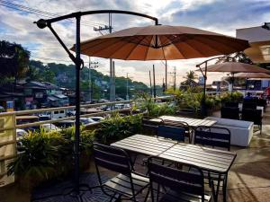 a patio with tables and chairs and an umbrella at 8 JOAQUIN'S Place WIFI Free! in Antipolo