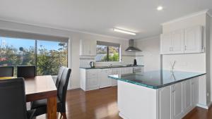 a kitchen with white cabinets and a counter top at Sea For Miles - Scenic Coastal Retreat in Lakes Entrance