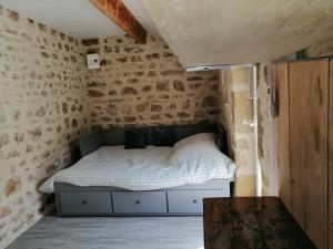 a bedroom with a bed in a brick wall at La salamandre in Vic-le-Comte