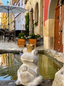 una estatua de piedra sentada junto a una piscina de agua en Gästehaus Alter Keller en Rothenburg ob der Tauber