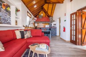 a living room with a red couch and a table at Recanto Jardim Do Mar in Jardim do Mar