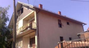 a white building with a balcony and a fence at Hostel Golub in Zaječar