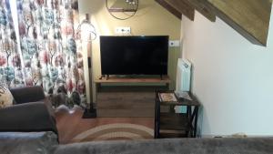 a living room with a flat screen tv on a table at La Borda de Garbi in Piedrafita de Jaca