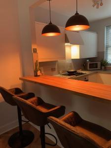 a kitchen with a bar with four bar stools at Skippers Retreat (with free doorstep parking) in North Berwick