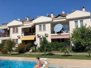 a woman in a pool in front of a house at Mariner Apartment in Fethiye