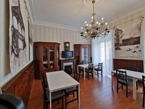 a dining room with tables and chairs and a chandelier at Plaza Pombo B&B - Hostal in Santander