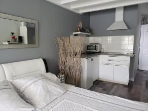 a bedroom with a bed and a kitchen with a microwave at Studio Zure Ondoan - SPA et piscine chauffée in Labenne