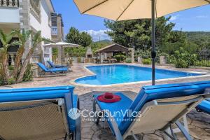 een zwembad met stoelen en een parasol bij PARADISE VILLA by Coral Sun Villas in Kato Yialia