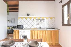 コニル・デ・ラ・フロンテーラにあるFinca Abril 3 Piscina Compartidaのキッチン(テーブル、洗濯機、乾燥機付)