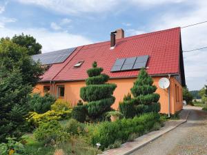 une maison dotée d'un toit rouge avec des panneaux solaires dans l'établissement UDany Wypoczynek, à Wojanów