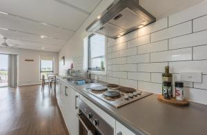 a kitchen with a stove top oven next to a counter at Vineyard Views at Shiraz Republic in Cornella