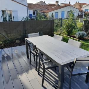 een houten tafel en stoelen op een terras bij Maison le Havre de la Gachère, 2 chambres, 2 salles d'eau, parking privé et jardin in Brem-Sur-Mer +12 foto's
