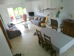 a living room with a table and a couch at La maison des Bruyères in Orbigny