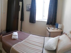 1 dormitorio con 1 cama con 2 toallas en County Hotel, en Helensburgh