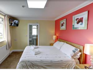 a bedroom with a bed with a red wall at County Hotel in Helensburgh