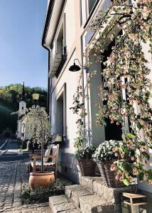 un edificio con flores a un lado. en Ráj na zemi venkovský hotel a kavárna en Hukvaldy