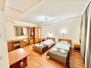 ein Hotelzimmer mit 2 Betten und einem TV in der Unterkunft Hotel 7F in Kiew