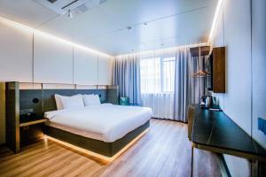 Amber Hotel Jeju في جيجو: غرفة نوم بسرير ابيض كبير ونافذة كبيرة