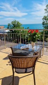 una mesa y sillas en un balcón con vistas al océano en Marianna, en Adler