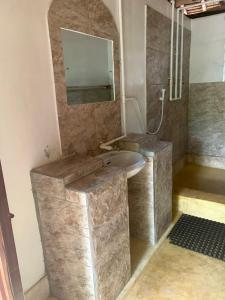 a bathroom with a sink and a mirror at Stilts Diani Beach in Diani Beach
