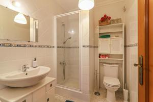 a bathroom with a shower and a toilet and a sink at Casa do Algarve in Albufeira +13 photos