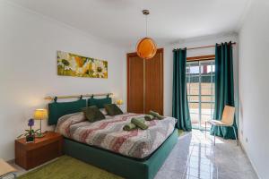Schlafzimmer mit einem Bett mit grüner Tagesdecke in der Unterkunft Casa do Algarve in Albufeira