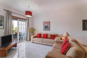 ein Wohnzimmer mit einem Sofa und einem TV in der Unterkunft Casa do Algarve in Albufeira
