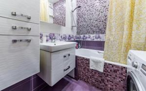 モスクワにあるKutuzoff Metro Polezhaevskaya Apartmentの紫と白のバスルーム(シンク、バスタブ付)