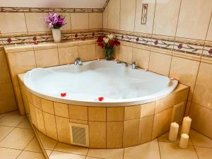 a large bath tub in a bathroom with flowers at Apartamenty i Pokoje u Doroty in Karpacz