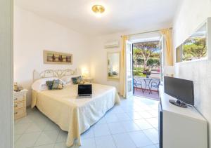 Un dormitorio con una cama y un televisor y un balcón. en Hotel Grazia alla Scannella, en Isquia 37 fotos más