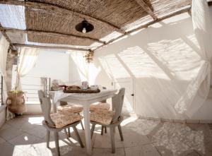 a dining room with a white table and chairs at Dimora Baronia in Latiano