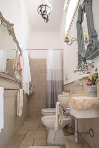 bagno con lavandino, servizi igienici e specchio di Dimora Baronia a Latiano
