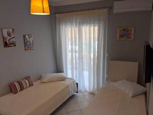 two beds in a room with a window at Artemis Apartments in Lefkada
