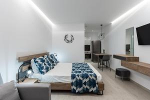 ein Schlafzimmer mit einem Bett und ein Wohnzimmer in der Unterkunft POUNEDES LUXURY SUITES in Pefki Rhodes