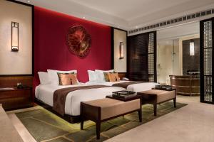 a bedroom with a large bed and a red wall at Banyan Tree Macau in Macau