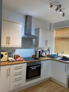cocina con armarios blancos y fogones en Pillow Properties - Barnsley Centre en Barnsley