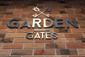 a sign on a brick wall with the words garden cities at Garden Gates Apartments by Renters in Gdańsk