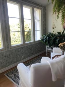 a living room with white furniture and windows at Susannes B&B in Västerbo