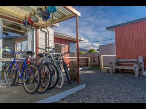 - un groupe de vélos garés à côté d'un bâtiment dans l'établissement Te Anau Holiday Home - Free WIFi - Free Bikes & Kayaks - Short Walk to Lake & Town - Top Views, à Te Anau